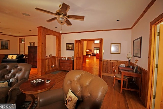 living room with ornamental molding, ceiling fan, and hardwood / wood-style flooring