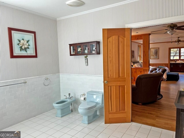 bathroom with tile flooring, toilet, a bidet, ceiling fan, and tile walls