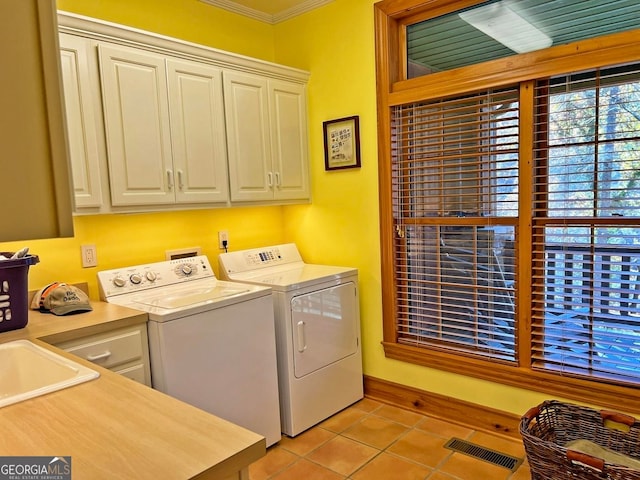 washroom with light tile floors, sink, washing machine and dryer, cabinets, and crown molding