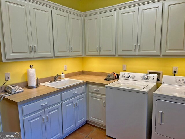 laundry room featuring washing machine and dryer, dark tile floors, hookup for a washing machine, cabinets, and sink