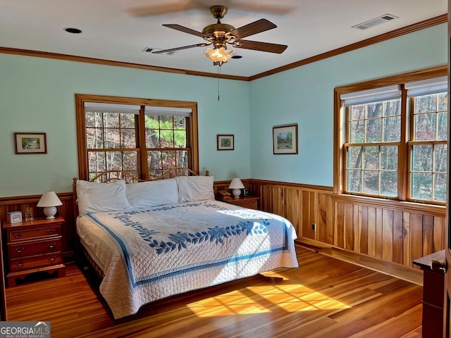 bedroom featuring hardwood / wood-style floors, ornamental molding, and ceiling fan