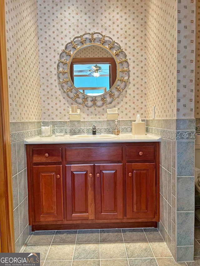 bathroom featuring tile flooring, tile walls, and vanity