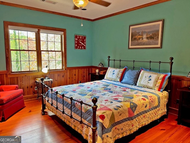 bedroom featuring ceiling fan, ornamental molding, and hardwood / wood-style flooring