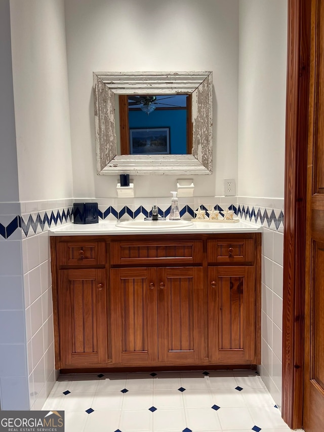 bathroom with dual vanity, tile flooring, and tile walls