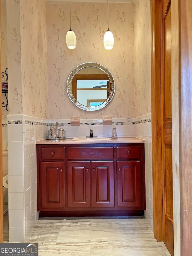 bathroom with tile walls, toilet, vanity, and tasteful backsplash