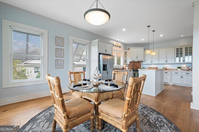 dining space featuring light wood-type flooring and sink