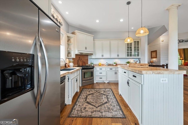 kitchen with decorative light fixtures, light hardwood / wood-style flooring, white cabinetry, and stainless steel appliances