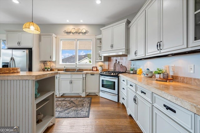 kitchen featuring stainless steel appliances, backsplash, decorative light fixtures, dark hardwood / wood-style flooring, and white cabinetry