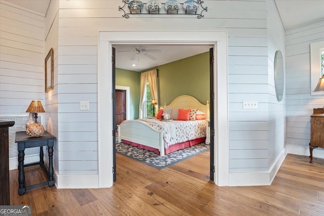 bedroom featuring wood walls and hardwood / wood-style flooring