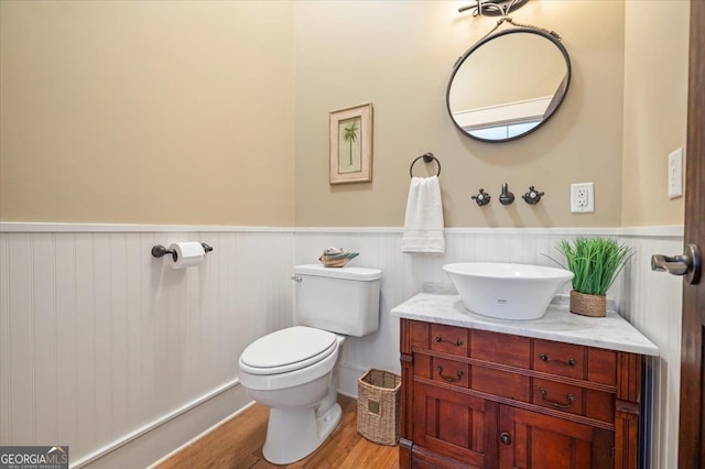 bathroom featuring toilet, hardwood / wood-style flooring, and vanity