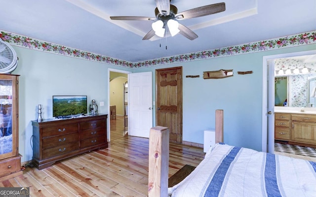 bedroom featuring ceiling fan, light hardwood / wood-style flooring, and ensuite bath