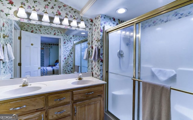 bathroom featuring a shower with shower door, double sink, and oversized vanity