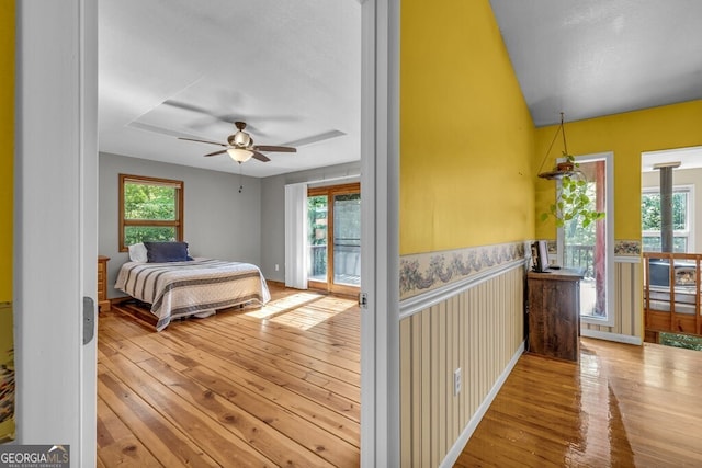 805 Quail Cove Cir, Warne, NC 28909 - bedroom with access to exterior, wood-type flooring, multiple windows, and wainscoting