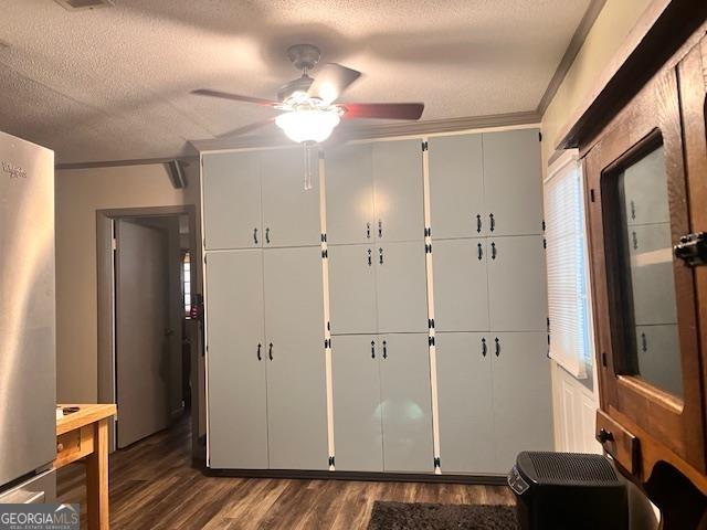 interior space with stainless steel fridge, ceiling fan, dark wood-type flooring, and a textured ceiling