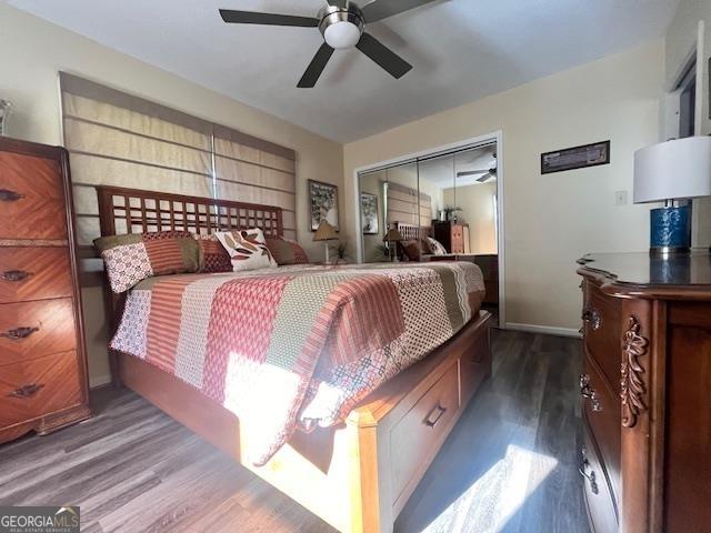 bedroom featuring a closet, dark wood-type flooring, and ceiling fan