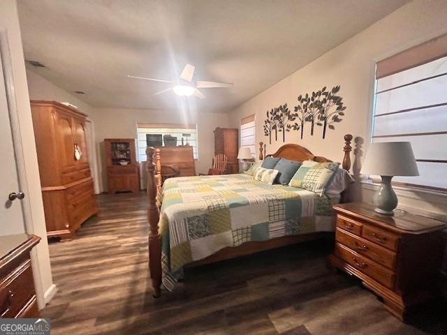 bedroom with ceiling fan and dark wood-type flooring