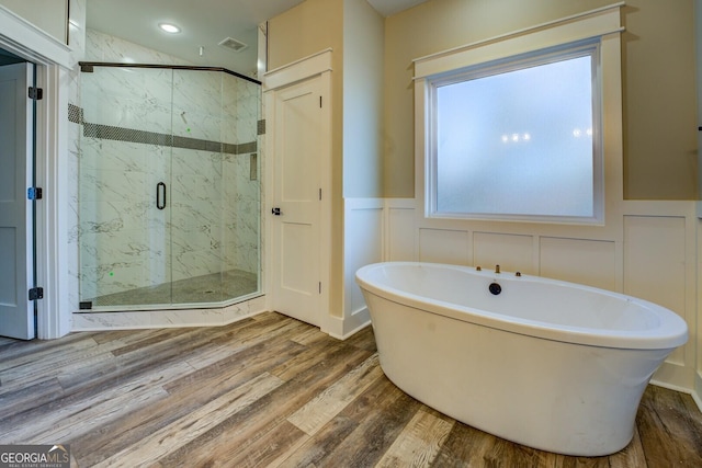 bathroom with plus walk in shower and hardwood / wood-style floors