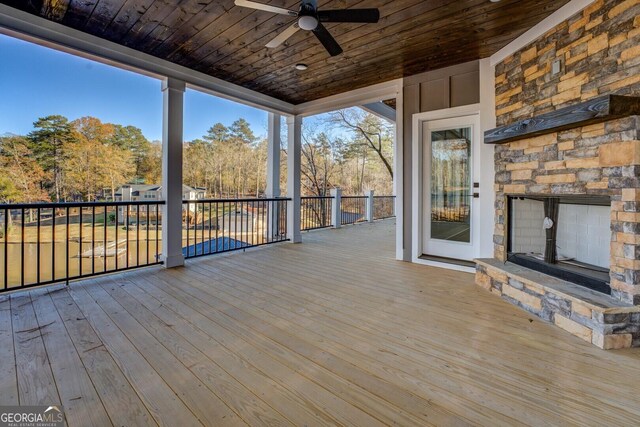 wooden terrace with a fireplace and french doors