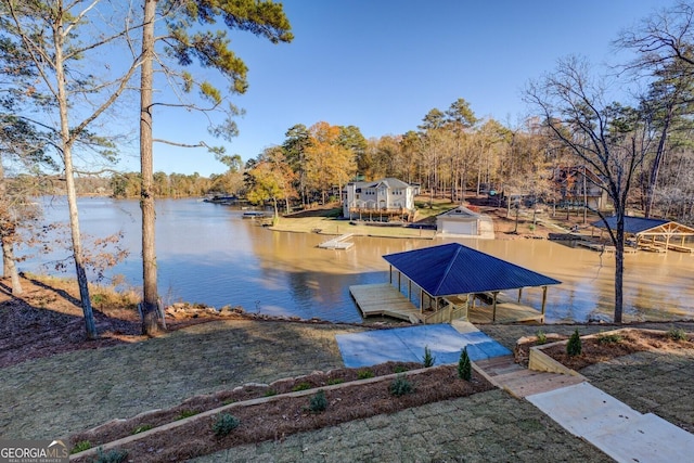 dock area with a lawn and a water view