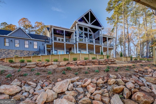 back of property with ceiling fan and a balcony