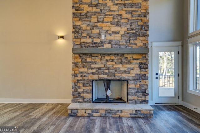 details featuring hardwood / wood-style flooring and a stone fireplace