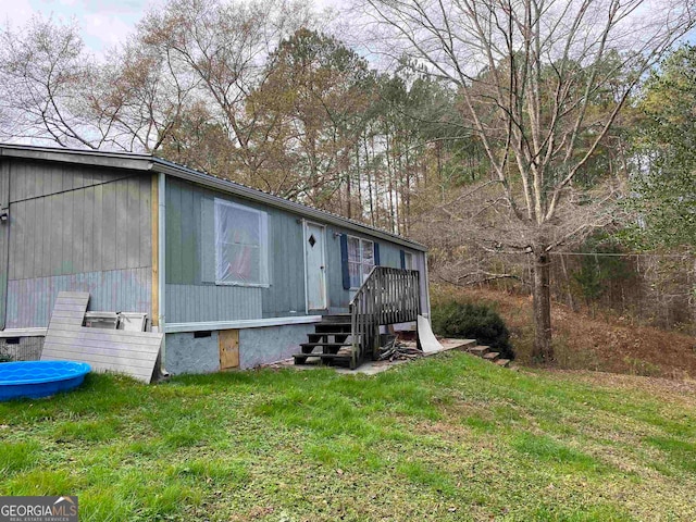 view of side of property featuring a deck and a lawn