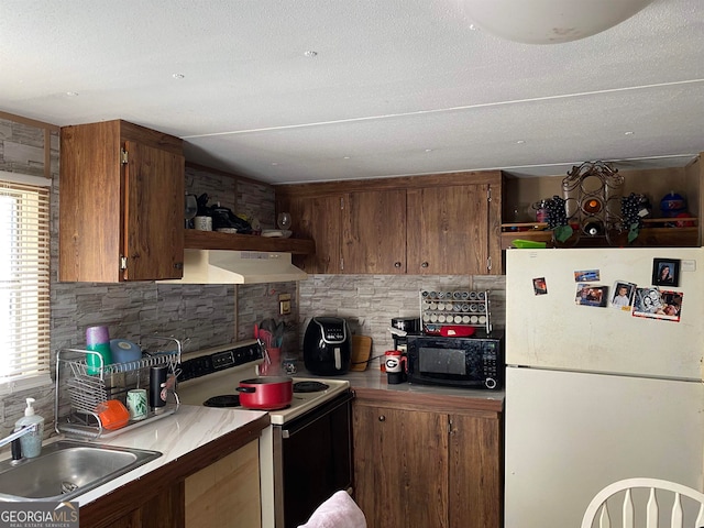 kitchen featuring white fridge, backsplash, range with electric cooktop, sink, and wall chimney exhaust hood