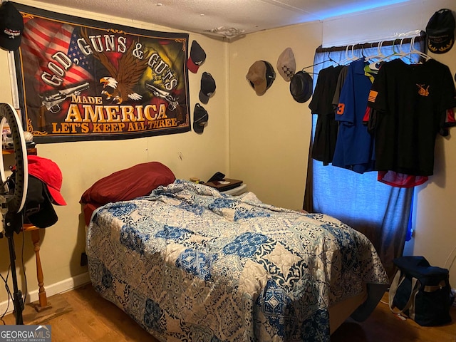 bedroom featuring a textured ceiling and hardwood / wood-style flooring