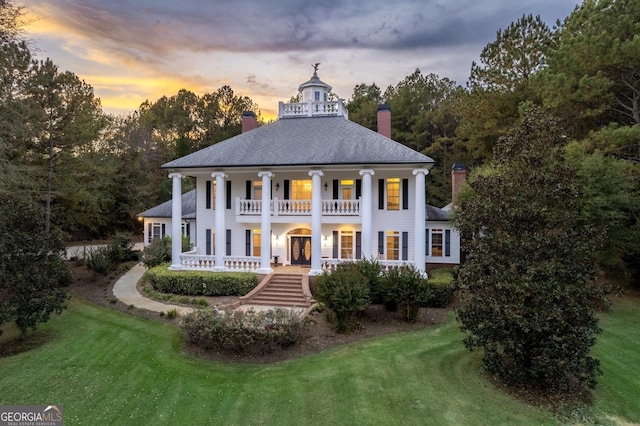 neoclassical / greek revival house with covered porch, a yard, and a balcony