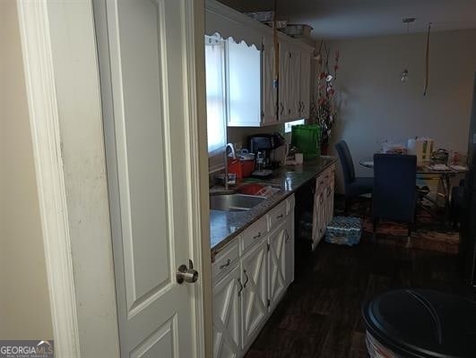 kitchen with sink, dark hardwood / wood-style flooring, and white cabinets