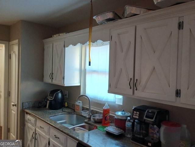 kitchen featuring sink and white cabinets