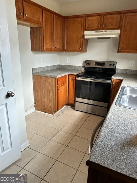 kitchen with light tile patterned floors, sink, and stainless steel range with electric stovetop