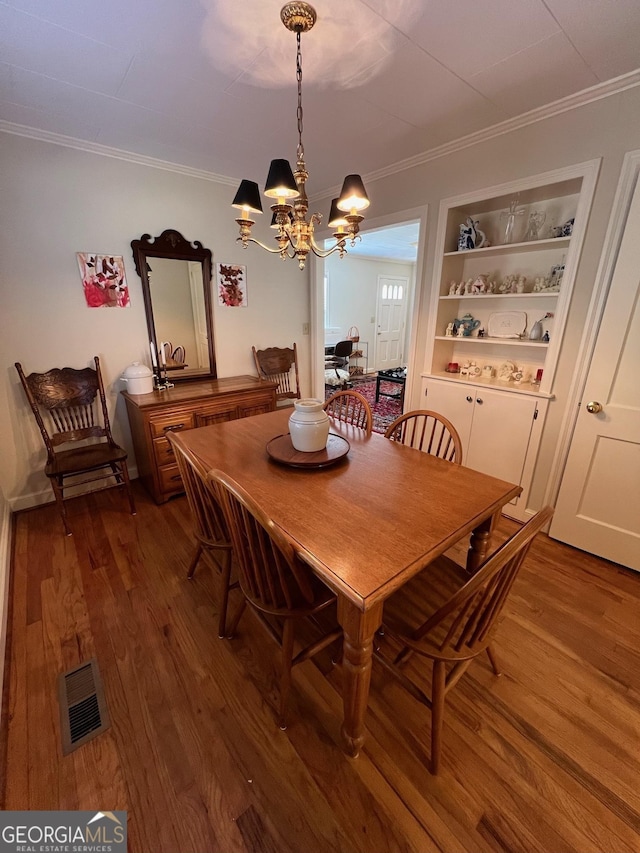 dining area with visible vents, crown molding, and wood finished floors