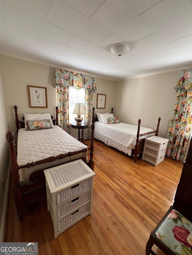 bedroom featuring light wood-style floors and ornamental molding