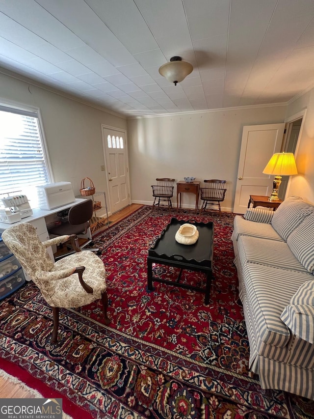 living room featuring baseboards, ornamental molding, and wood finished floors