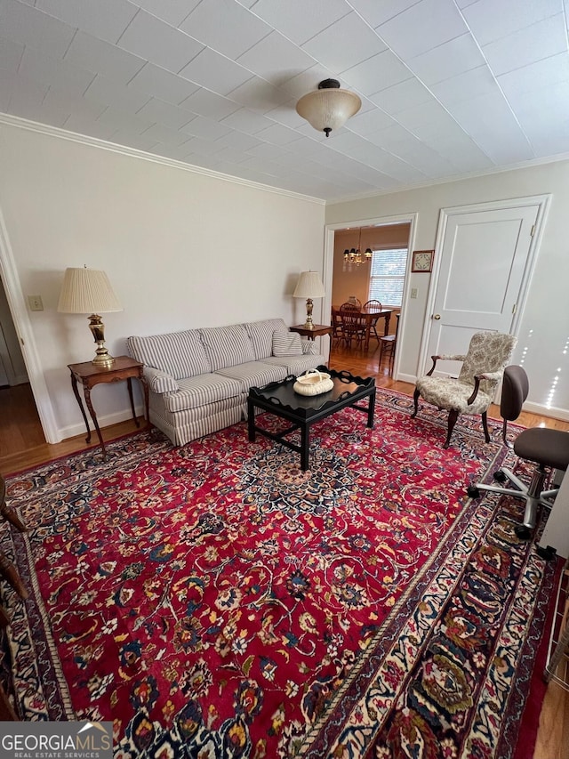 living room featuring crown molding, baseboards, and wood finished floors