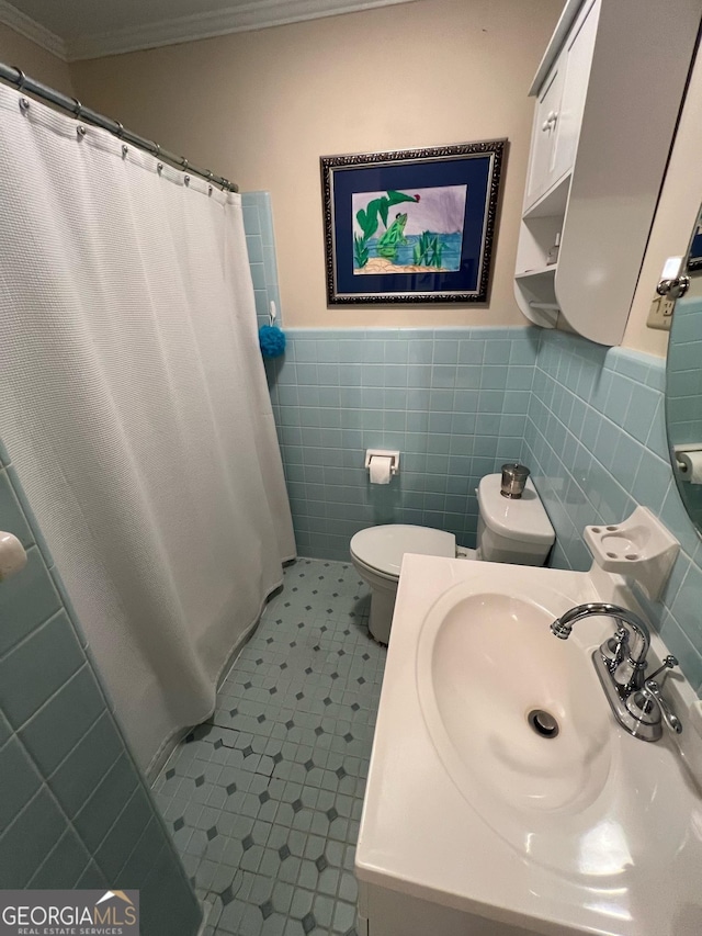 full bath with toilet, a shower with shower curtain, tile walls, wainscoting, and crown molding