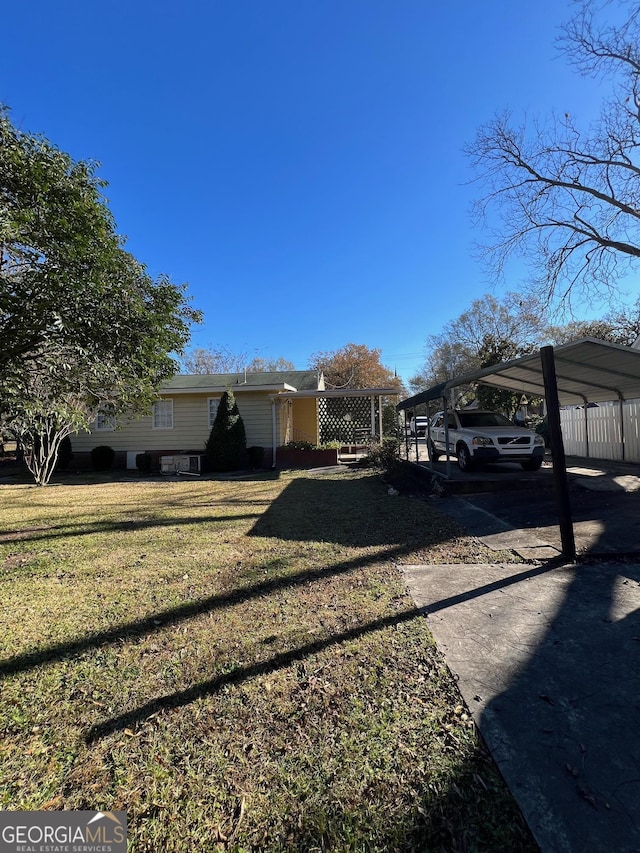 view of front of property featuring fence, a carport, and a front yard