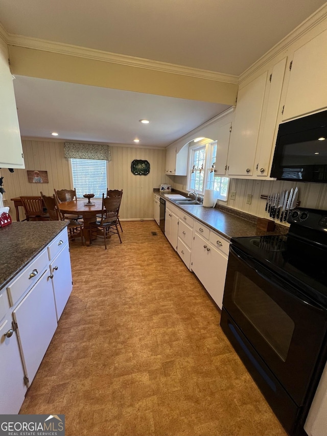 kitchen with dark countertops, white cabinets, and black appliances