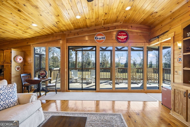 living room featuring wooden walls, wood ceiling, vaulted ceiling, and light wood-type flooring