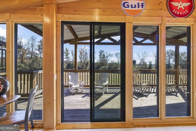 doorway to outside featuring a healthy amount of sunlight, vaulted ceiling, and light wood-type flooring