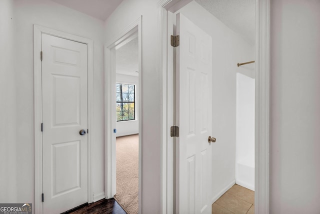 hallway with dark tile flooring