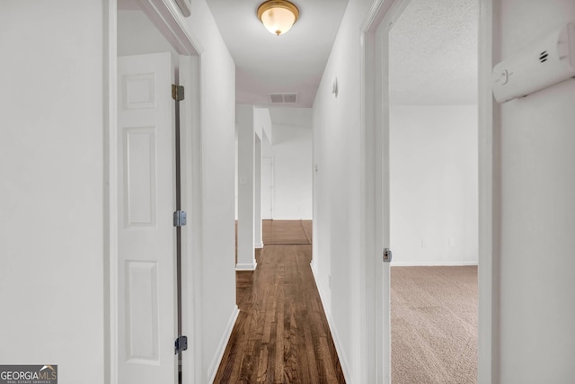 hall featuring dark colored carpet