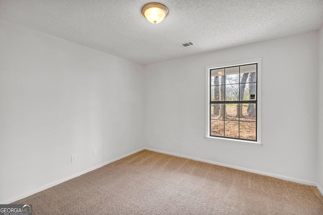 carpeted spare room with a textured ceiling