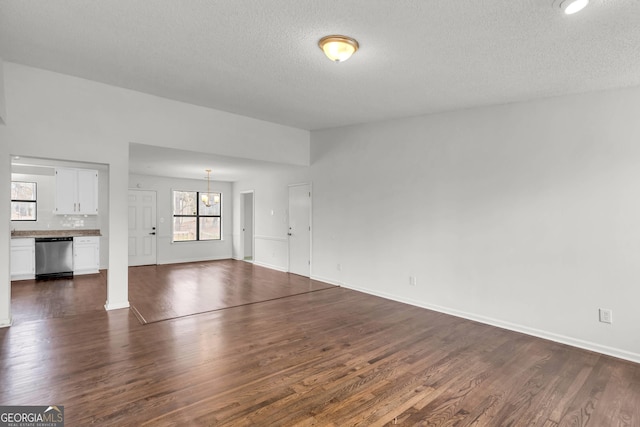 unfurnished living room featuring dark hardwood / wood-style flooring and a textured ceiling