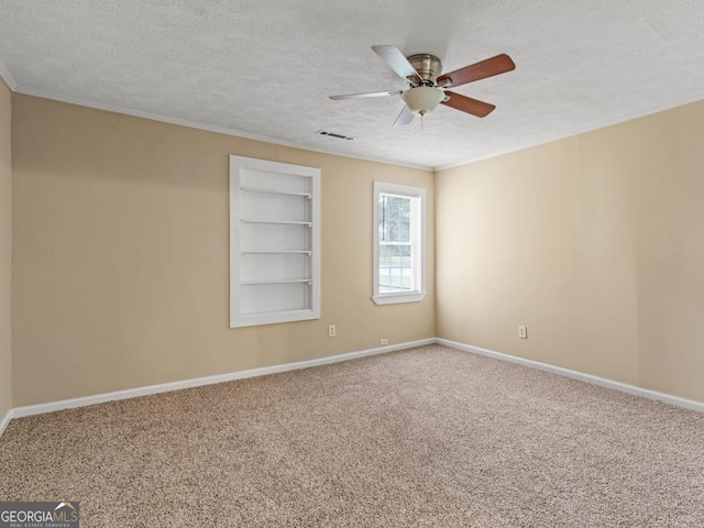 carpeted spare room with built in shelves, ceiling fan, and a textured ceiling