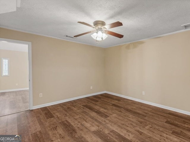 spare room with a textured ceiling, ceiling fan, dark hardwood / wood-style flooring, and ornamental molding