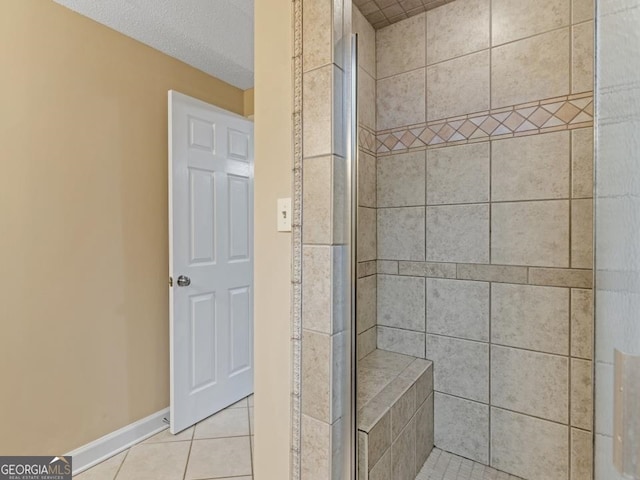 bathroom with a tile shower and tile flooring