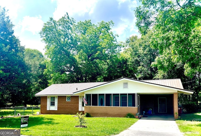 single story home with a sunroom, a front yard, and a carport