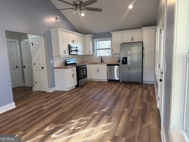 foyer with dark hardwood / wood-style floors, ceiling fan, and high vaulted ceiling